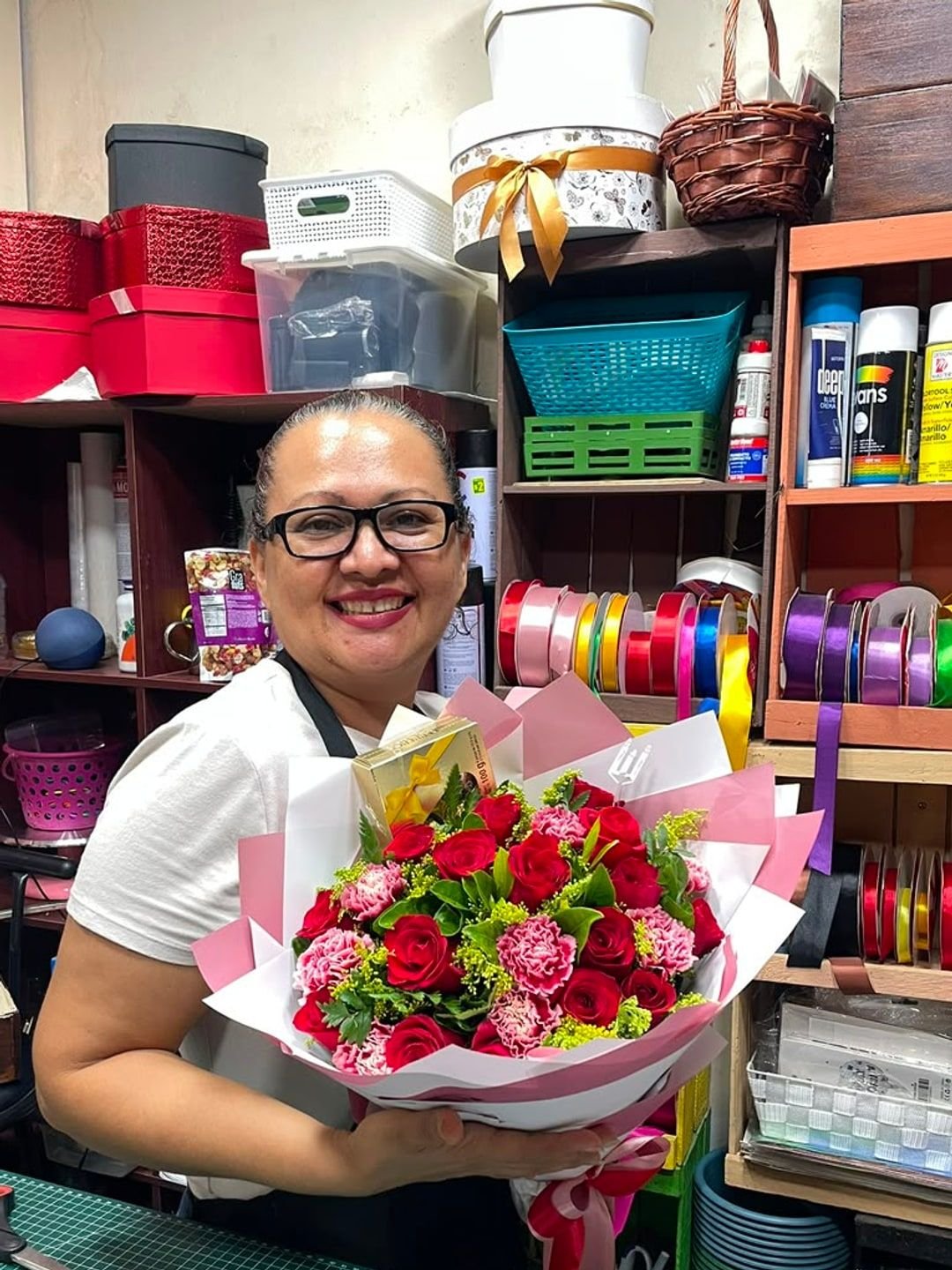 María sosteniendo un bouquet de rosas en su taller.